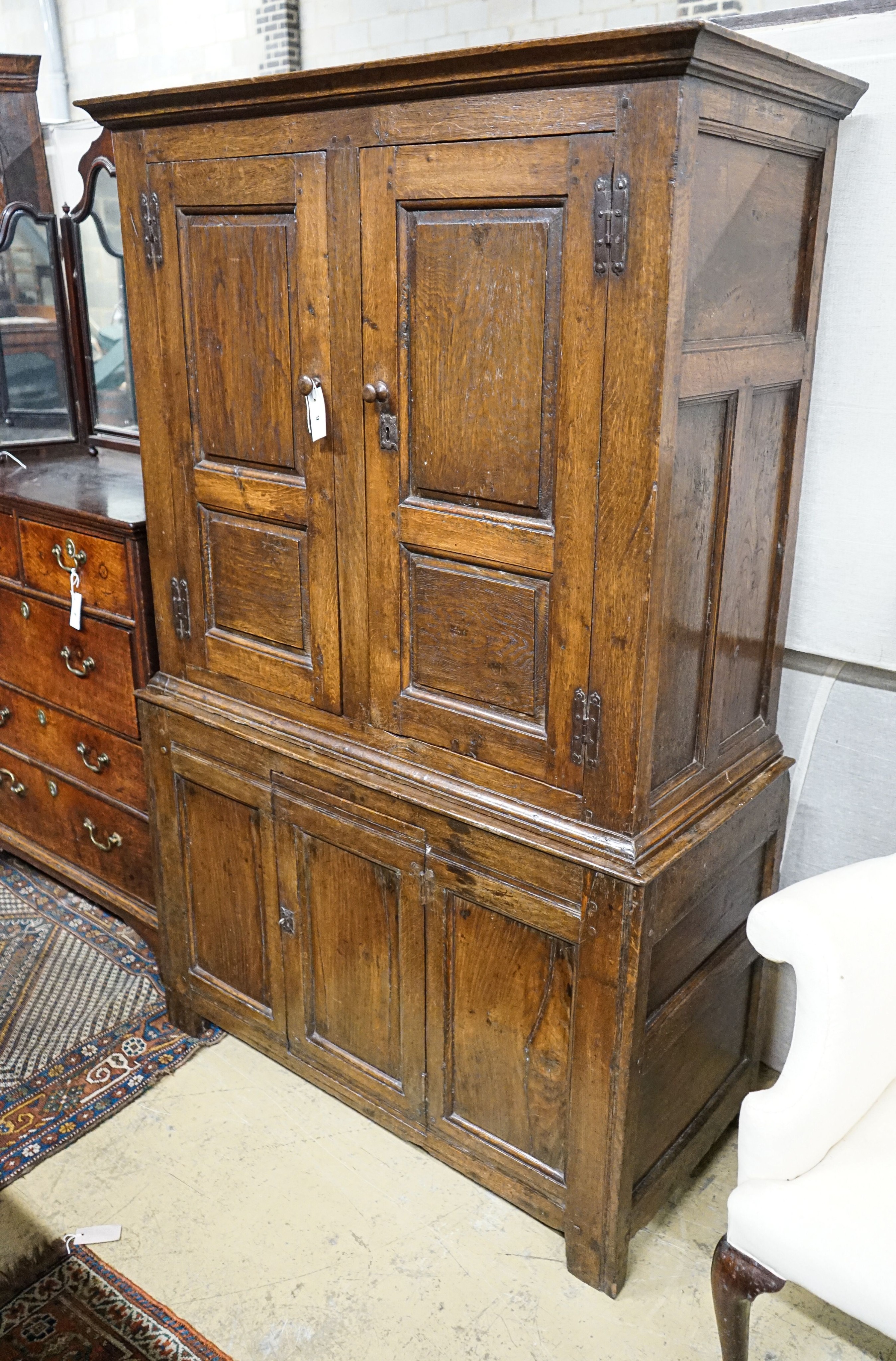 A 17th century style oak press cupboard, with three panelled doors, width 108cm, depth 50cm, height 172cm